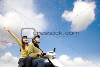 Happy young couple  having fun on a scooter