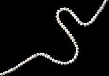 White pearls on the black silk as background 
