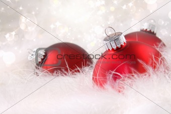 Red christmas balls in white feathers 