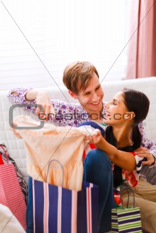 Young guy helping her girlfriend to choose dress
