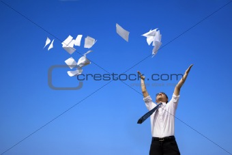 business man relaxing and throwing white papers  to the blue sky