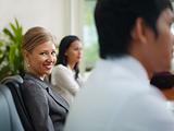 businesspeople talking in meeting room and woman smiling
