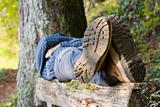 Hiker lying on a wooden bench
