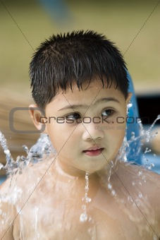 kid playing with water fountain