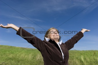 Attractive mature woman enjoying life on the meadow