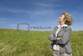 Beautiful, joyful mature woman on the meadow