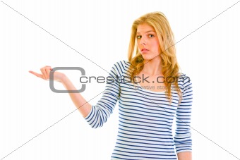 Confused teen girl pointing in corner
