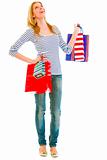 Full length portrait of smiling teen girl with shopping bags looking up
