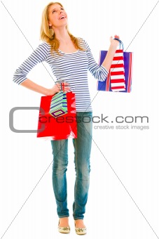 Full length portrait of smiling teen girl with shopping bags looking up
