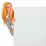 Portrait of teen girl holding blank billboard
