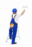 Handyman or worker painting with roller brush leaning on ladder