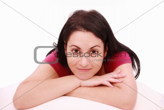 Beautiful young brunette woman lying on the bed