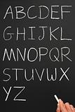 The alphabet in capitals written with white chalk on a blackboar