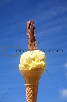 A yellow ice cream with a chocolate flake.