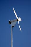 Small electricity generating wind turbine spinning with motion blur movement.