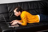 girl on sofa with laptop, she watches the display with expressio