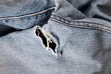 Hole in an old pair of blue jeans