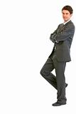 Smiling modern businessman standing back to imaginary wall
