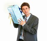 Modern businessman shaking present box trying to guess what's inside