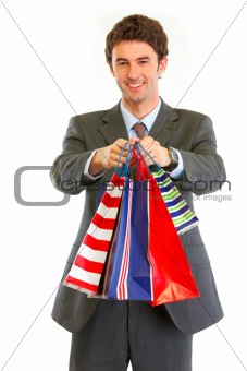 Portrait of smiling modern businessman with shopping bags
