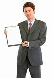 Smiling modern businessman giving clipboard for you to sign
