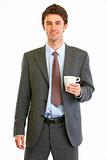 Portrait of happy modern businessman with coffee cup in hand
