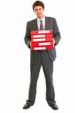 Unhappy modern businessman holding stack of folders
