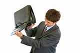 Modern businessman shakes out something from briefcase
