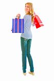 Smiling teen girl with shopping bags looking back
