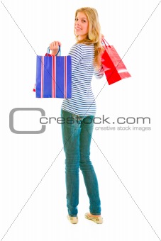Smiling teen girl with shopping bags looking back
