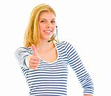 Smiling beautiful teen girl in headset showing thumbs up
