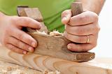 Worker hands closeup - planing wood