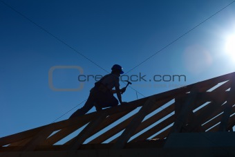 Carpenter or joiner working on top of the roof