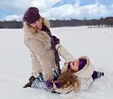 Woman and little girl having fun in the snow