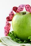 Diet concept Ripe green apple with measuring tape
