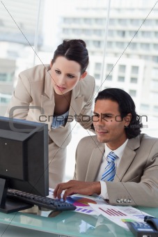 Portrait of a business team studying statistics while using a computer
