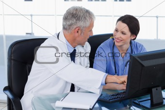 Smiling medical team working with a computer