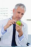 Portrait of a doctor putting his stethoscope on an apple