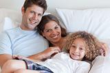 Smiling family relaxing on a bed
