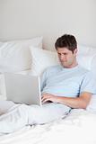 Man surfing the internet in bed
