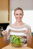 Smiling woman stirring salad