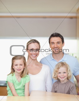 Cheerful family standing in the kitchen together