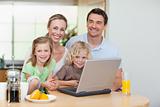 Smiling family using the internet in the kitchen