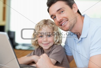 Smiling father and son with notebook