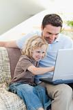 Father and son with notebook on sofa