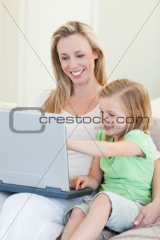 Mother and daughter with laptop on couch