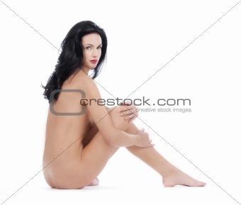 beautiful nude woman with dark hair looking at camera - isolated on white