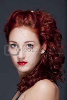 beautiful teenage woman with red hair looking - isolated on gray