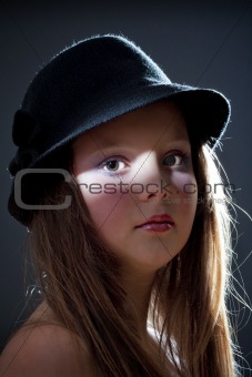 dramatic portrait of a twelve years old girl with hat