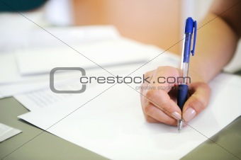Female hand writing in document